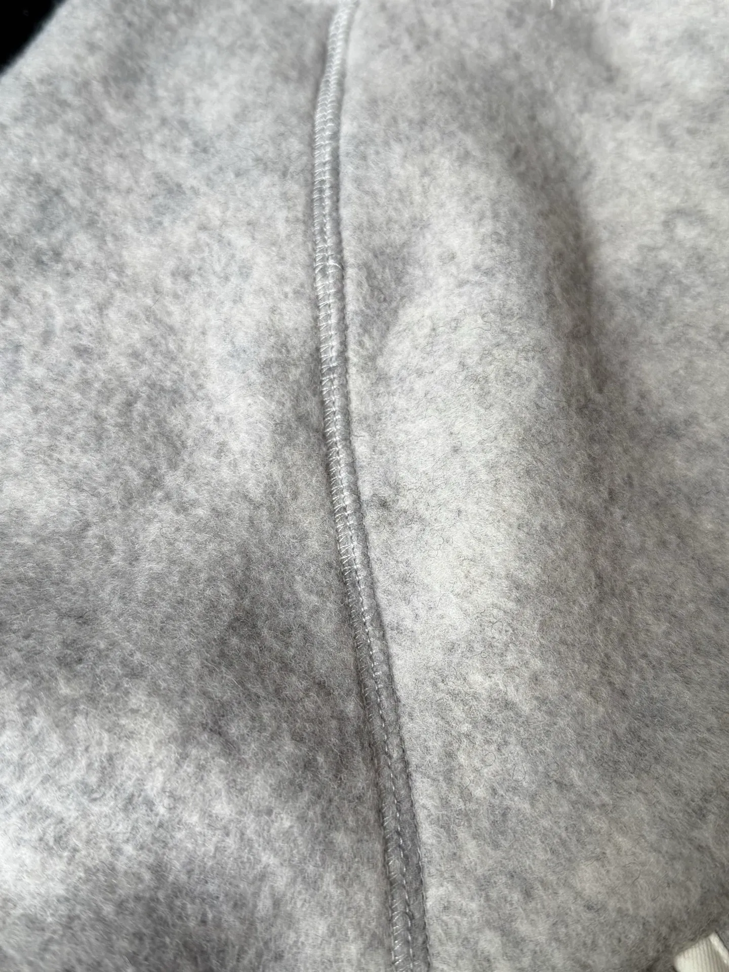 P620 Canada Goose Fleece Wool Baseball Jacket Fabric selection: Wool fleece fabric blended with wool as the main body and a very small amount of spandex and polyester fiber. Wool is a core natural ingredient that provides unparalleled temperature regulation, antibacterial and anti-odor properties and a skin-friendly feel. The feeding of a small amount of spandex gives the fabric a certain degree of four-way elasticity, making it non-restrictive during daily activities. As the basis of fleece's structure, polyester fiber enhances the fabric's durability, wrinkle resistance and quick-drying properties. It contributes to the loft of the fleece and provides functions such as trapping air.  Detail 1: The sleeves and hem are closed with 2×2 ribbing. Its strong elasticity can closely fit wrists and waists of different thicknesses, forming an effective 'seal' to prevent cold wind from blowing back. It can still maintain its original shape after repeated stretching and use, and is not easy to loose and deform. And the ribbed cuffs can convey a sense of design and enhance the visual beauty.  Detail 2: The combination of hood design and elastic buckle improves warmth and windproof performance when wearing. Accessories: Customized elastic drawstring, elastic buckle, custom zipper pendant, custom armband Size: S M L Color: Black Gray Mickey